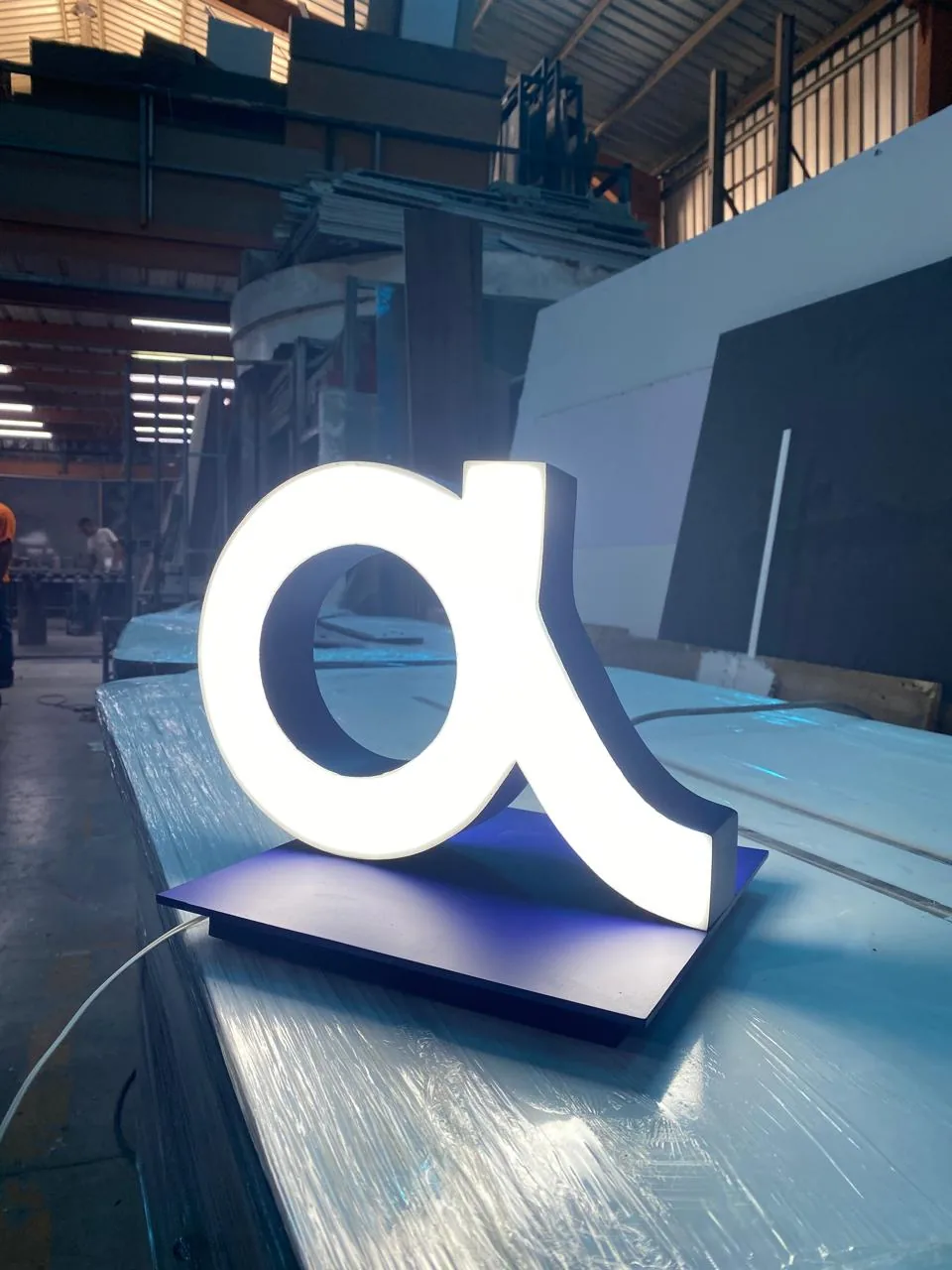 Rótulo corporativo iluminado en producción